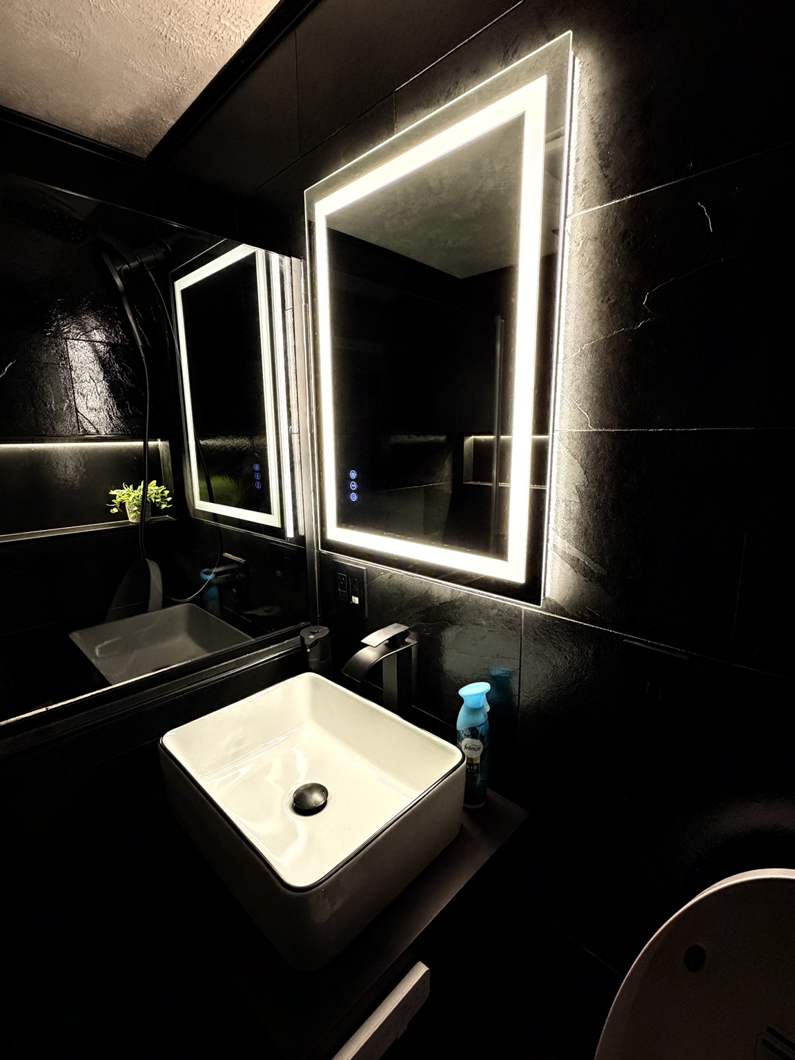 Finished bathroom vanity with vessel sink and illuminated mirror