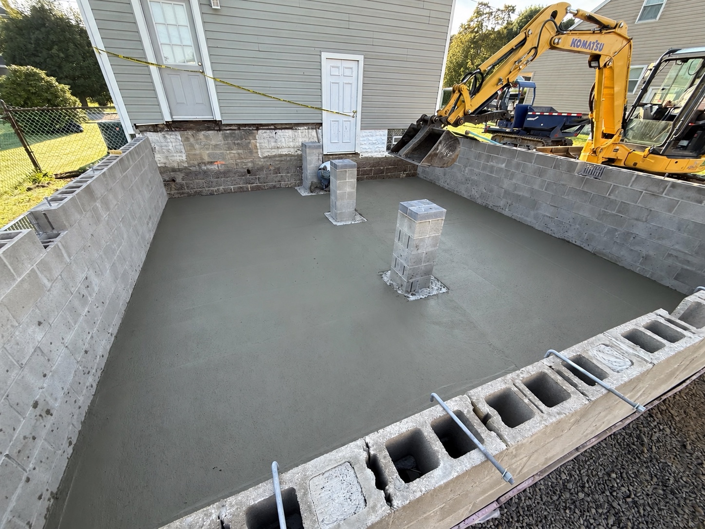 Newly poured concrete floor inside the block foundation for a house addition