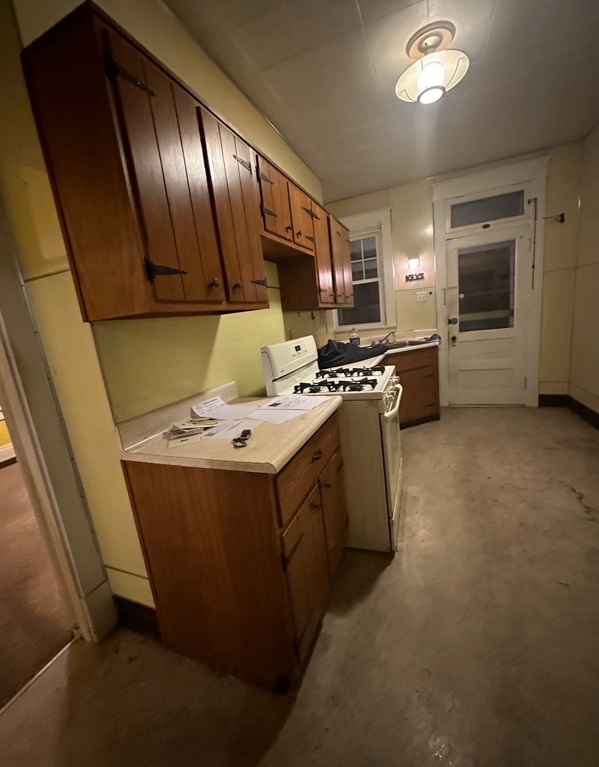 Kitchen before renovation with dark wood cabinets and dated finishes
