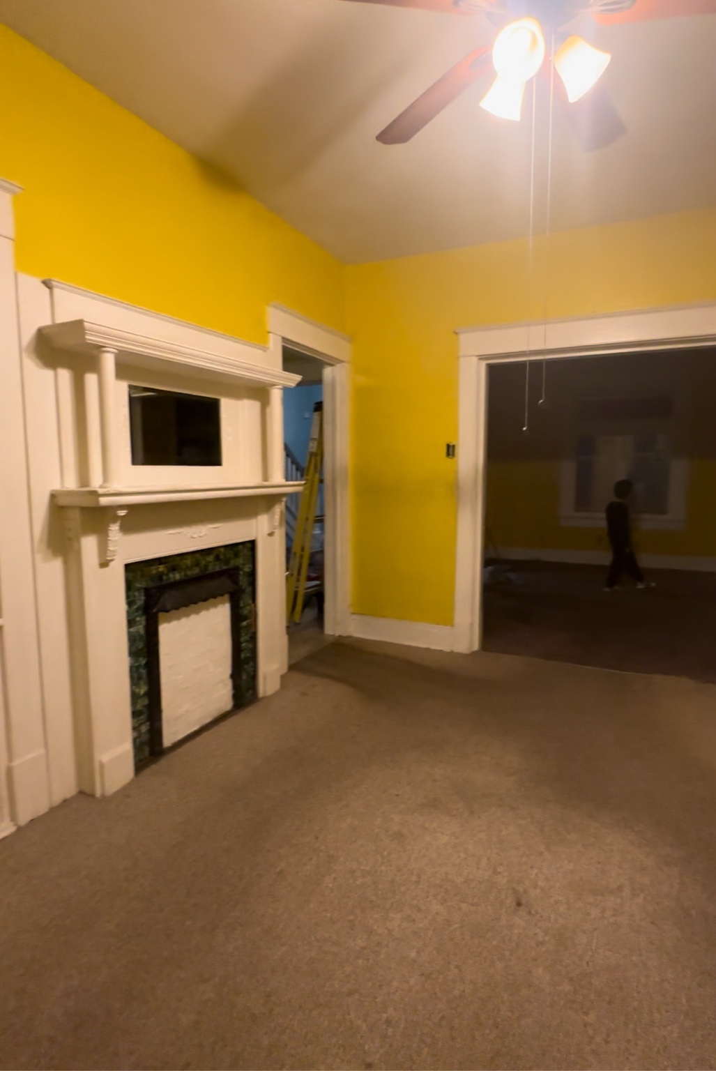 Living room before renovation with yellow walls and carpet