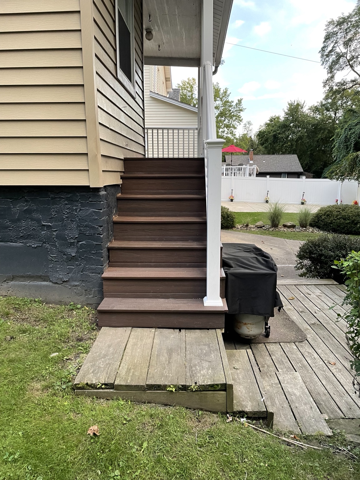 New brown exterior deck steps with white railing